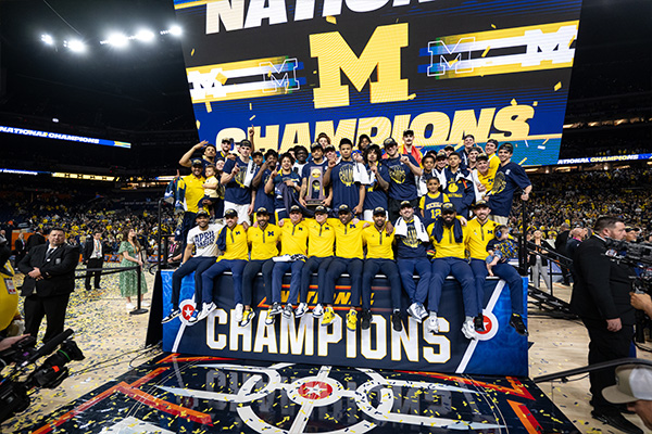 Men's basketball team with the national championship trophy