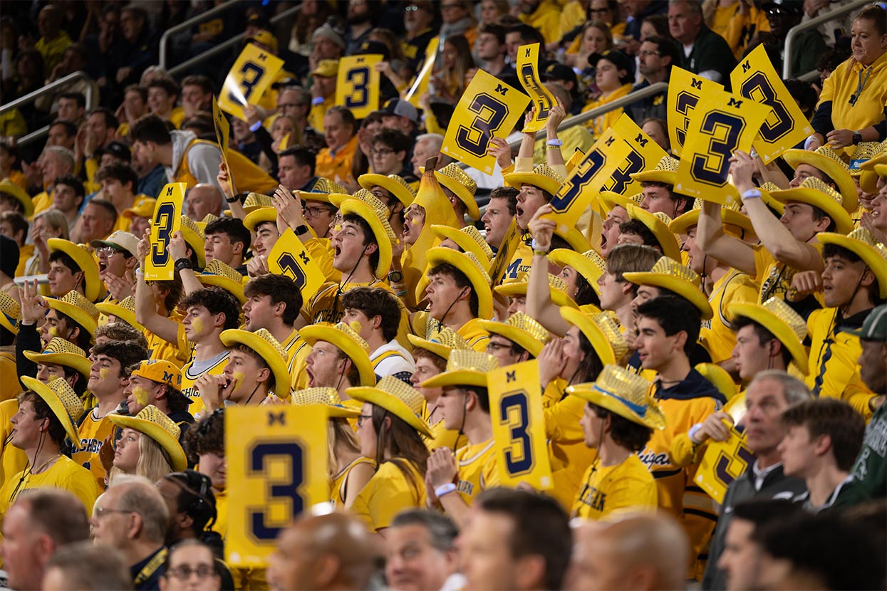Students in maize holding maize 3-point signs