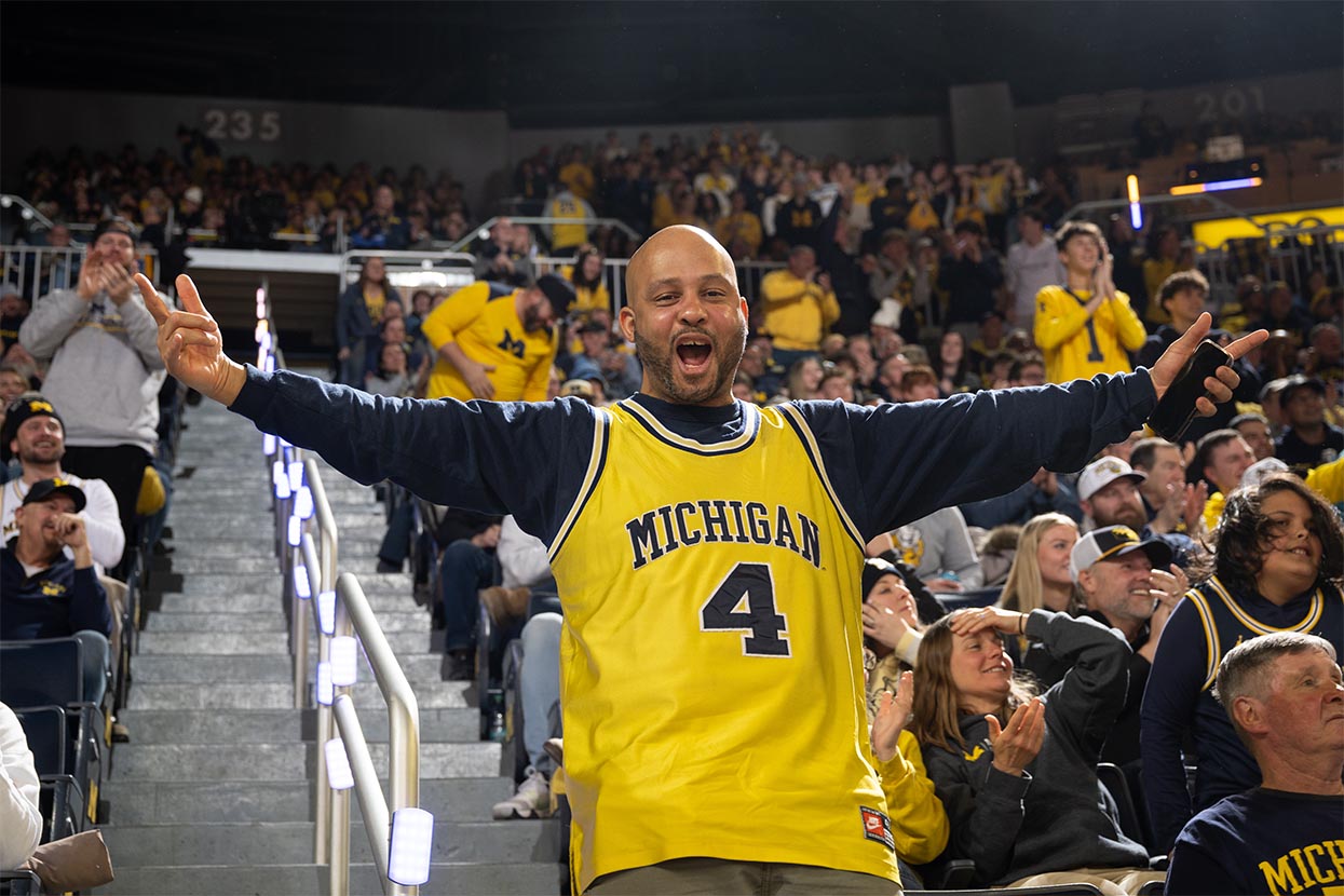 Fan wearing a maize Michigan basketball jersey