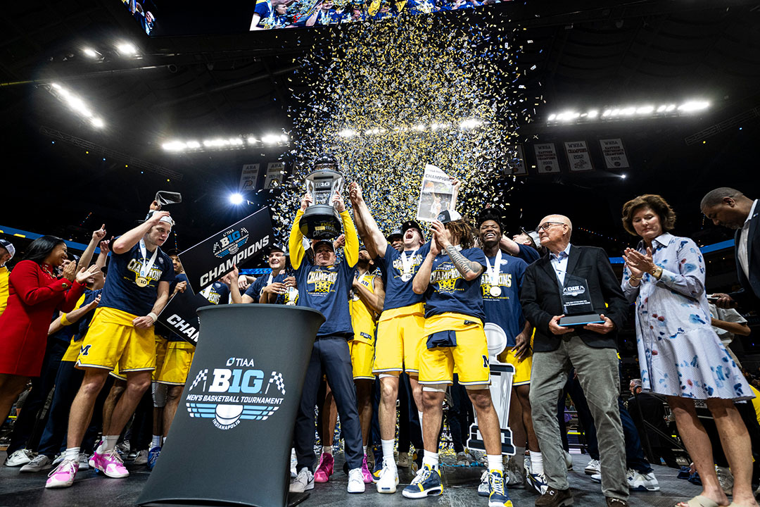 Dusty May and men's basketball raise the Big Ten Tournament trophy while confetti falls