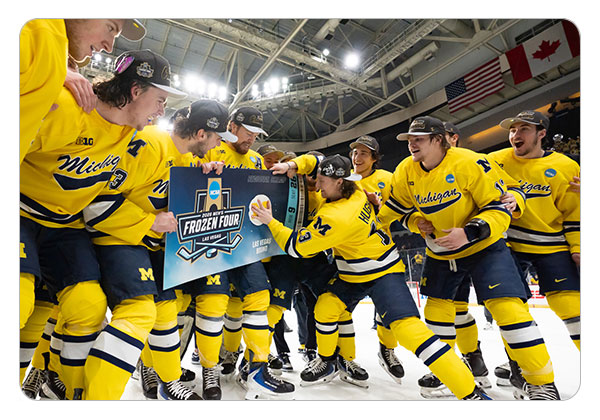 T.J. Hughes putting the Michigan logo on the NCAA Frozen Four ticket after the win over Minnesota Duluth