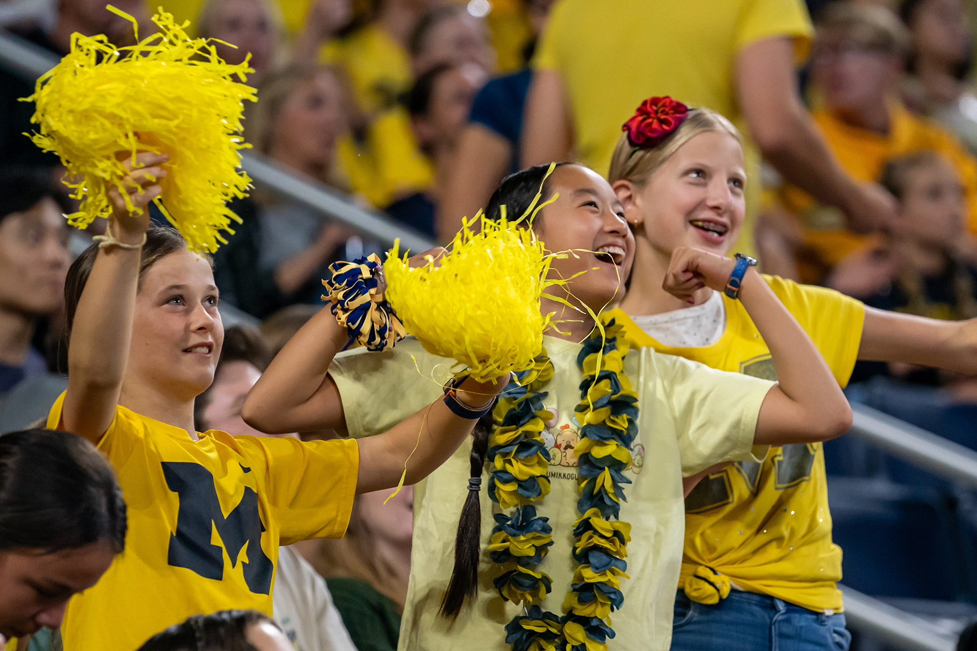 Kids in maize Michigan gear and holding maize poms